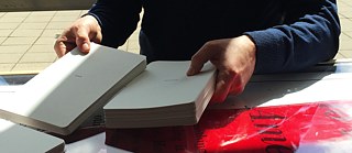 A visitor is preparing the “Exquisite Corpse” card decks for a group game