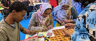 Les visiteurs jouent Busara au stand. © © Enter Africa Les visiteurs jouent Busara au stand.
