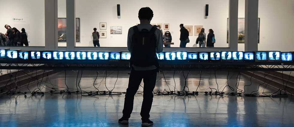 Un visitante frente a la instalación "Quindío-Pass" de José Alejandro Restrepo en Bogotá