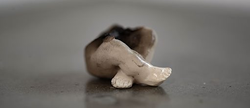 Scultpture en céramique représentant des jambes croisées et modifiée par des micro-ondes