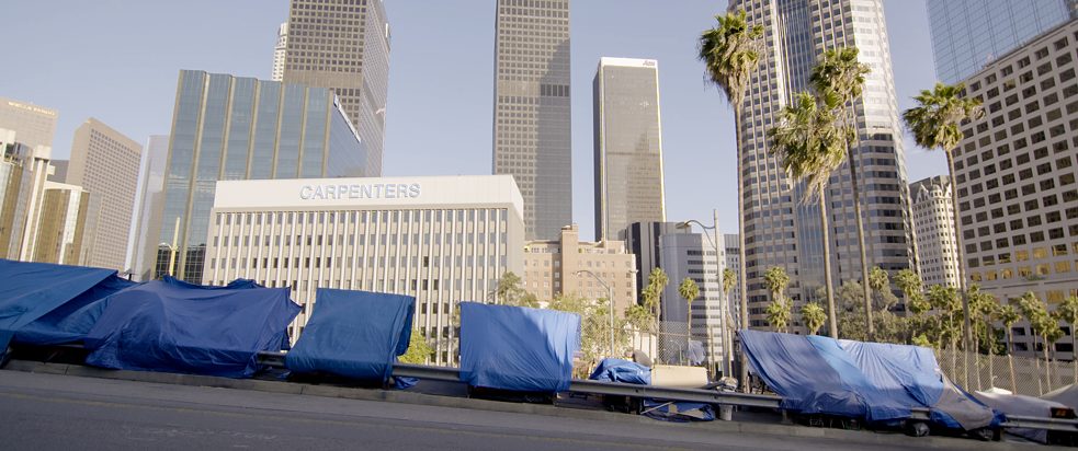 Stillframe from the CCA film "What it takes to make a home" - Tarps tightened in between a fence and a guard rail in Los Angeles