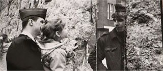 Amerikanischer Soldat mit Tochter auf dem Arm sieht durch ein Loch in der Mauer