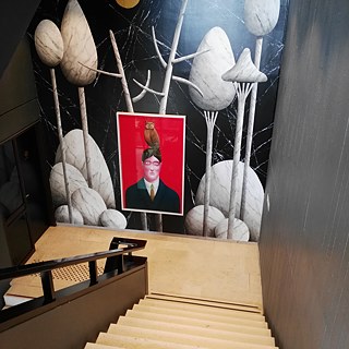 <b>Magritte Museum (Brüssel, Belgien)</b><br><br>„There is no choice: there is no art without life.“ – René Magritte<br>2009 öffnete das Magritte Museum seine Türen. Seitdem beherbergt es 230 Werke des renommierten Künstlers René Magritte. Als Teil der Königlichen Museen der Schönen Künste befindet es sich zentral in der Hauptstadt Belgiens. Seit 2018 ist das Werk <i>Portrait with an Owl</i> des Künstlers Nicolas Party ausgestellt.