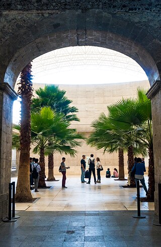 Besucher*innen warten im Innenhof auf die Ausstellungseröffnung