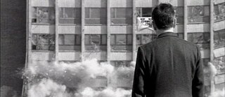 Scène du film 'Wege in die Nacht' :  Photographie en noir et blanc d’un homme regardant un immeuble s’effondrer.