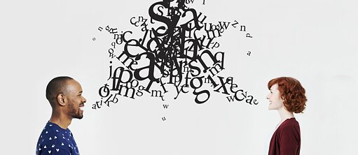 Seitenansicht eines Mannes und einer Frau, zwischen ihnen sieht man viele Buchstaben die durcheinander wirbeln.