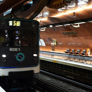 Celui qui pénètre dans la station de métro Arts et Métiers se retrouve littéralement au milieu des engrenages d'une construction mécanique. Dans le ventre de ce mystérieux "Nautilus", sous-marin fictif imaginé par Jules Verne, le visiteur attend la ligne 11 du métro entre onze hublots en laiton. Entièrement recouverte de cuivre brillant - c'est ainsi que l'artiste belge François Schuiten a conçu en 1994 cette station de métro unique en son genre pour le 200e anniversaire du Musée des Arts et Métiers. La voûte en forme de sous-marin transporte le visiteur dans un univers technico-industriel d'antan et lui rappelle l’existence du musée qui se trouve juste au-dessus. Attention au départ ! – vous descendez 200 000 lieues sous les mers...