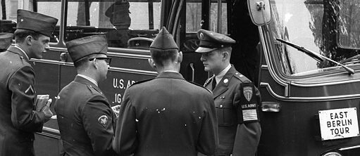 Des soldats américains devant leur bus affichant 'Tour à Berlin-Est'