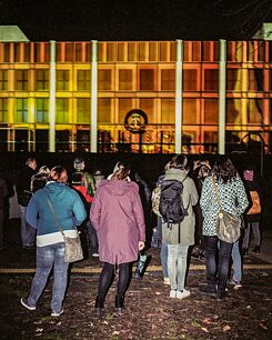 Ludze patrzący na Palast der Republik wyświetlany na Zamku Berlińskim