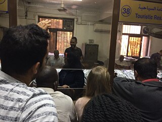 Ich und andere Wartende vor dem Schalter im Mogamma