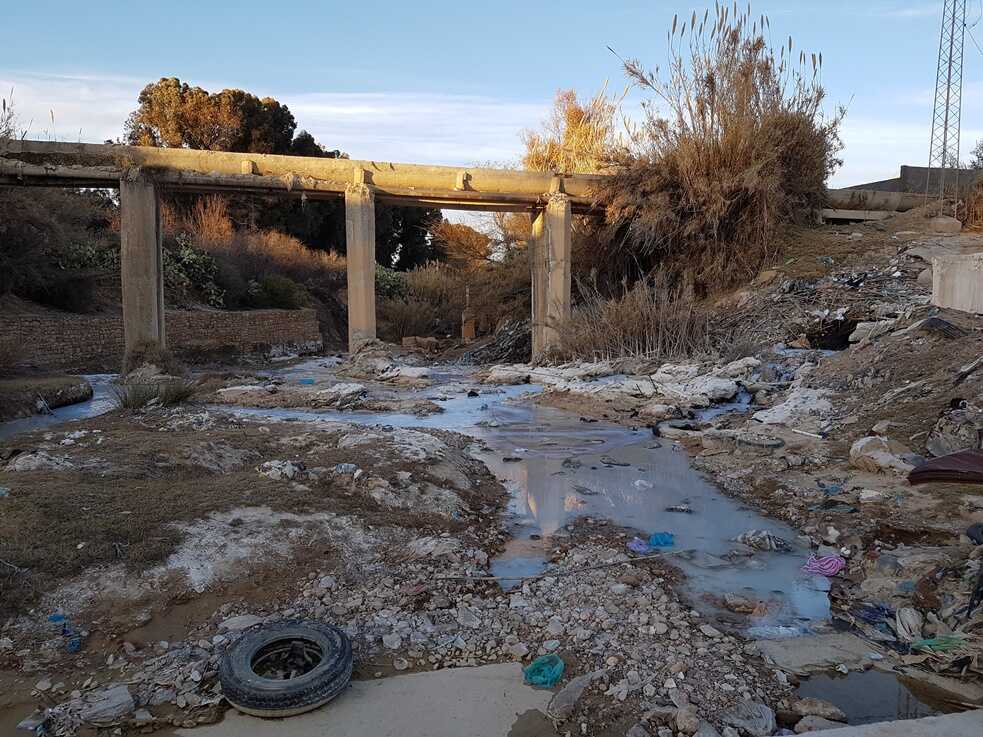 Image of a nearly dried out river filled with industrial water pollution.