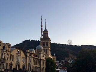 Berg und Riesenrad über Tbilisi