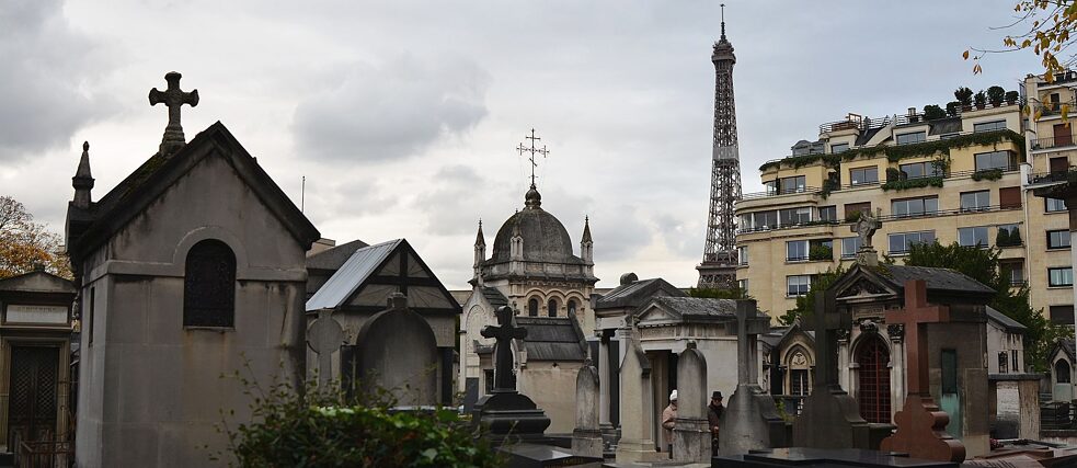 <b>Cimetière de Passy (Paris, France)</b><br><br> Dès votre arrivée au Cimetière de Passy, vous entrez dans un autre monde : la circulation et l'agitation touristique cessent et la monumentalité des tombeaux parisiens, si différents des tombeaux allemands, ressort tout particulièrement. Ouvert en 1820, le cimetière de Passy est rapidement devenu celui de l'aristocratie par sa proximité avec les Champs-Élysées et sa situation dans l’un des quartiers résidentiels les plus huppés de la capitale. En vous y promenant, vous tomberez sur de nombreux/-ses artistes et célébrité.e.s qui ont trouvé ici leur dernière demeure près de la Tour Eiffel qui surplombe les murs du cimetière, de l'autre côté de la Seine.