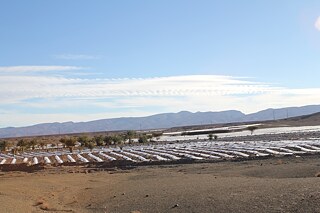 Dry landscape with cultivation of watermelons in the foreground.