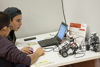 Die Schüler programmieren kleine Roboter.