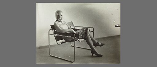 Dame assise (Lis Beyer ou Ise Gropius) sur une chaise en tuyaux d’acier de Marcel Breuer, masque d'Oskar Schlemmer, robe de Lis Beyer, photographie : Erich Consemüller, 1926