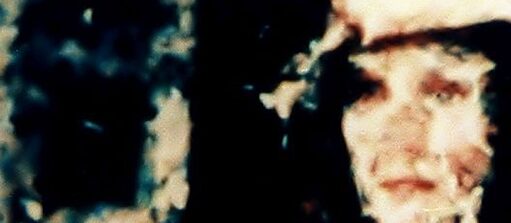 schwarzer Hintergrund; ein Gesicht ist auf der rechten Seite des Bildes zu erkennen; auf der linken Seite sind blau-weiße Schattierungen zu erkennen.