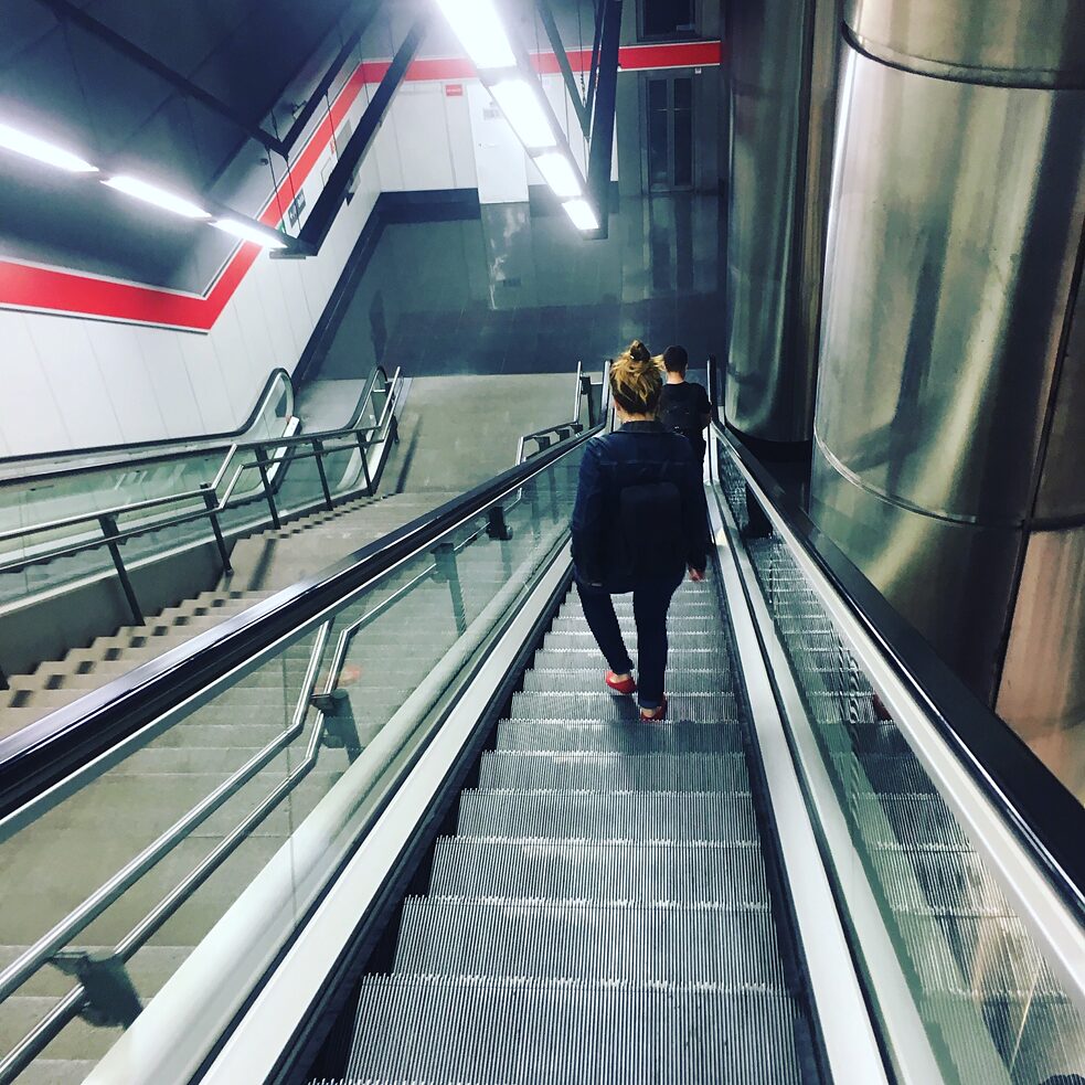 Irene bajando la escalera mecánica de la estación de Valdelasfuentes para coger el cercanías