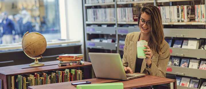 In der Bibliothek - mit Kaffee und Laptop