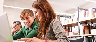 Kursteilnehmerin in Mediothek vor Laptop