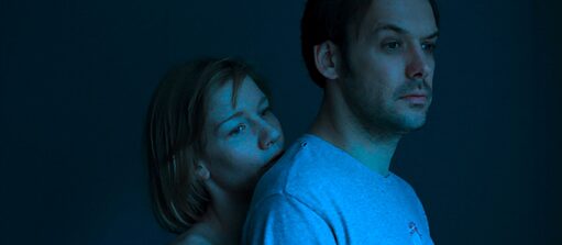 room during night, woman hugs a man from behind