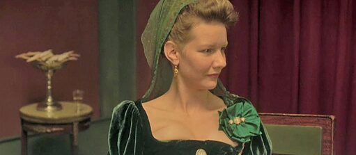 Sandra Hüller in a green dress; the detail of the photograph shows her torso and face; on her face an expression of disbelief