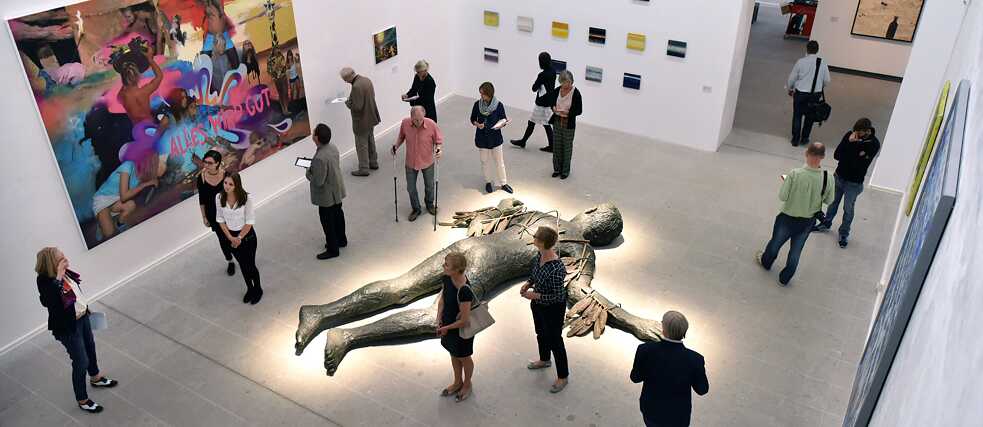 Besucher betrachten das Kunstwerk „Ikarus“ von Stephan Balkenhol in der Ausstellung „Wasser, Wolken, Wind. Elementar- und Wetterphänomene in Werken der Sammlung Würth“.