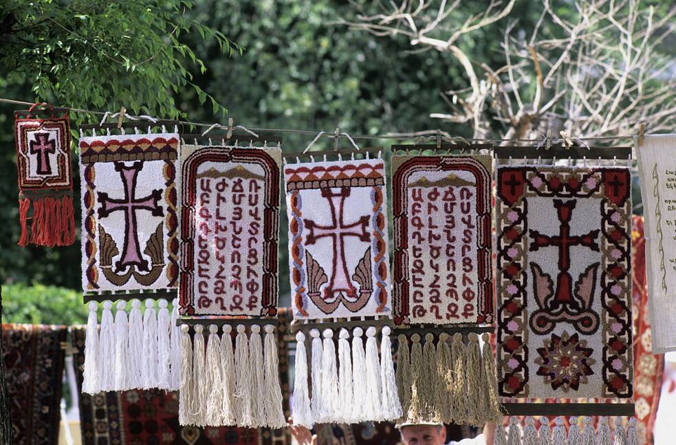 Tapetes com desenhos de cruzes e do alfabeto armênio. A caligrafia armênia e suas expressões culturais foram incluídas na lista do Patrimônio Cultural Imaterial da Unesco em 2019. A caligrafia armênia baseia-se no alfabeto armênio, desenvolvido há mais de 1.600 anos. Letras ricamente ornamentadas podem ser encontradas tanto em escrituras sofisticadas como em tapetes, esculturas de madeira e outros produtos artesanais. A caligrafia ocupa um papel importante na preservação da língua e da cultura armênias.