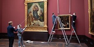 Raphael’s “Sistine Madonna” hangs directly one floor above. The painting “Christ Bearing the Cross” is being hung just to its right. 
