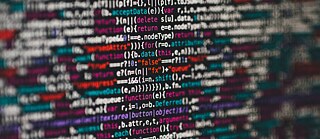 Nahaufnahme eines bunten Codes, der nur in der Mitte zu erkennen ist. Der Rest ist verschwommen.