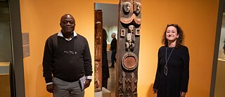 Karin Guggeis (rechts), Projektleiterin des Museums Fünf Kontinente München und Albert Gouaffo, Projektkoordinator der Universität Dschang (Kamerun), neben dem „Blauer-Reiter-Pfosten“