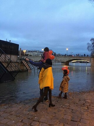 Santa mit Familie mit magischem Blick auf die überschwemmte Seine. Die Ballons durften die Kinder von einer Veranstaltung mitnehmen.