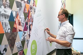 Former director of the Goethe-Institut Thailand, Wilfried Eckstein, leaves his birthday wishes on the anniversary board