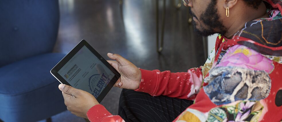 Ein Mann bedient die Anerkennung in Deutschland Webseite auf einem Tablet