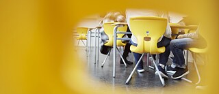 View of the lower part of a table where pupils are sitting. 