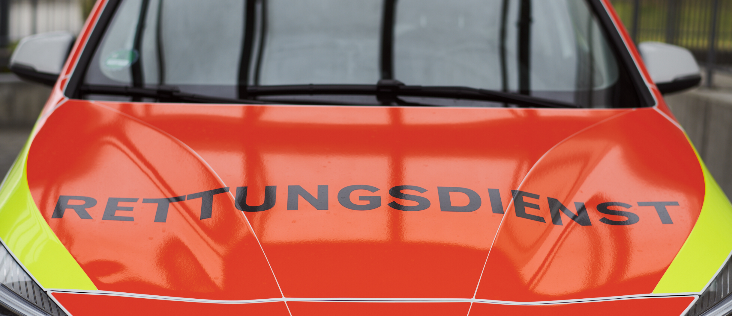 Ansicht von vorne auf einen orangenen Rettungswagen mit der Aufschrift 