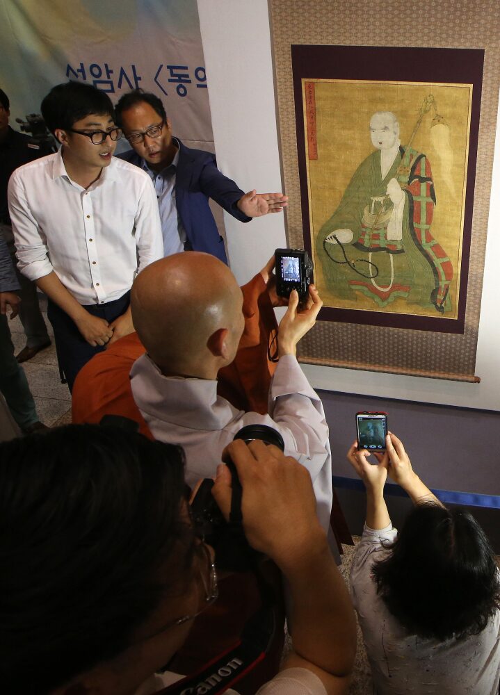 Dipinto buddista rubato del XVIII secolo e restituito dagli Stati Uniti. Un monaco e i visitatori rendono omaggio al ritratto di un grande monaco Seon (monaco zen) durante un evento svoltosi al Central Buddhist Museum di Seoul il 21 luglio 2015 per inaugurare l’esposizione del dipinto buddista. L’opera era conservata presso il tempio di Seonam a Suncheon, a sud di Seoul, prima di essere portata negli Stati Uniti. La Cultural Heritage Administration ha dichiarato che l’opera, che si considera risalente attorno al 1738, è stata donata da un americano che inizialmente, a marzo, l’aveva messa all’asta. L’amministrazione l’ha reclamata a giugno, chiedendo al collezionista di annullare la compravendita. 