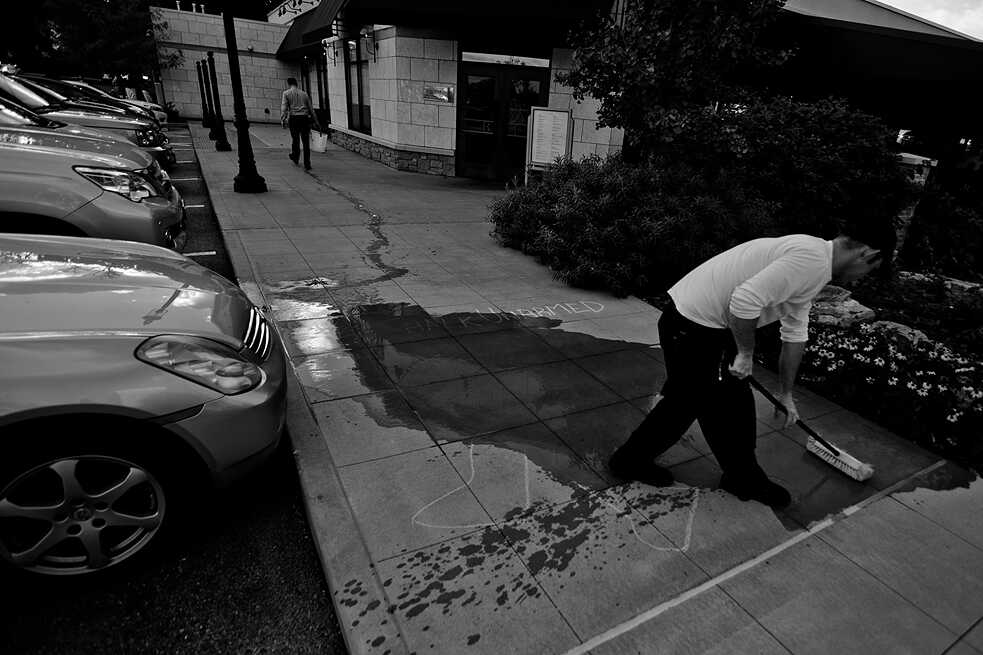 #ChalkedUnarmed. A store owner washing away a chalk drawing at Frontenac Mal in Frontenac, MO