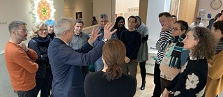 International theatre and festival directors listen to their guide during an exhibition.