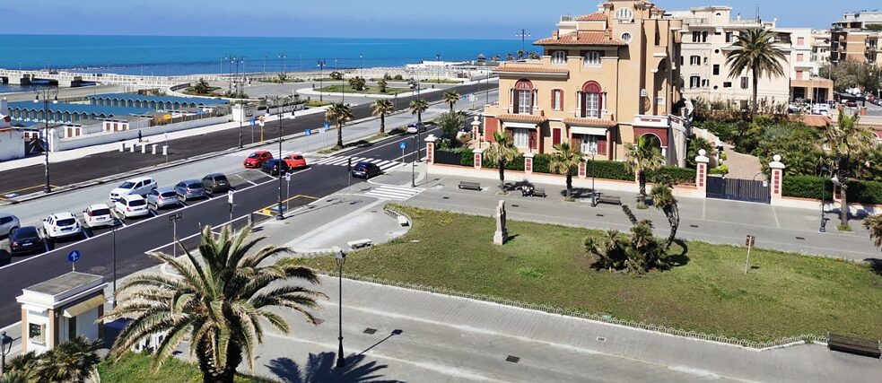 Ostia, an der römischen Küste. An sonnigen Tagen lieben es die Römerinnen und Römer hier an den Strand zu gehen oder in einem der vielen Fischrestaurants zu essen. Während des Lockdowns ist die Piazza, die normalerweise voller Menschen, Geschäfte, Cafés und Restaurants ist, wie leergefegt. (Lungomare Paolo Toscanelli und Piazza Anco Marzio) 