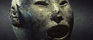 Aztekischer Kopf des Xipe Totec (Unser Herr, der Geschundene), altmexikanischer Frühlingsgott, bekleidet mit einer abgezogenen Menschenhaut. Stein. Hamburg, Museum am Rothenbaum – Kulturen und Künste der Welt (MARKK). 