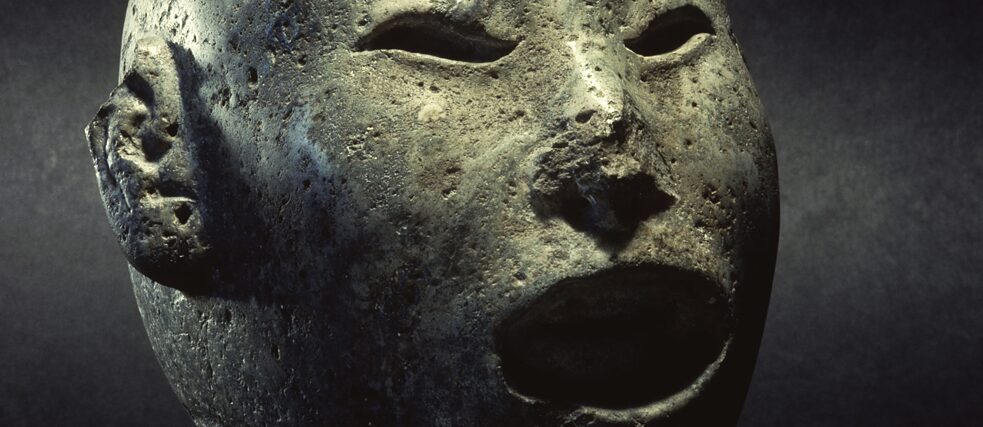 Aztec head of Xipe Totec (Our Lord, the oppressed), old Mexican spring god, dressed with a stripped human skin. Stone. Hamburg, Museum am Rothenbaum - Cultures and Arts of the World (MARKK). 