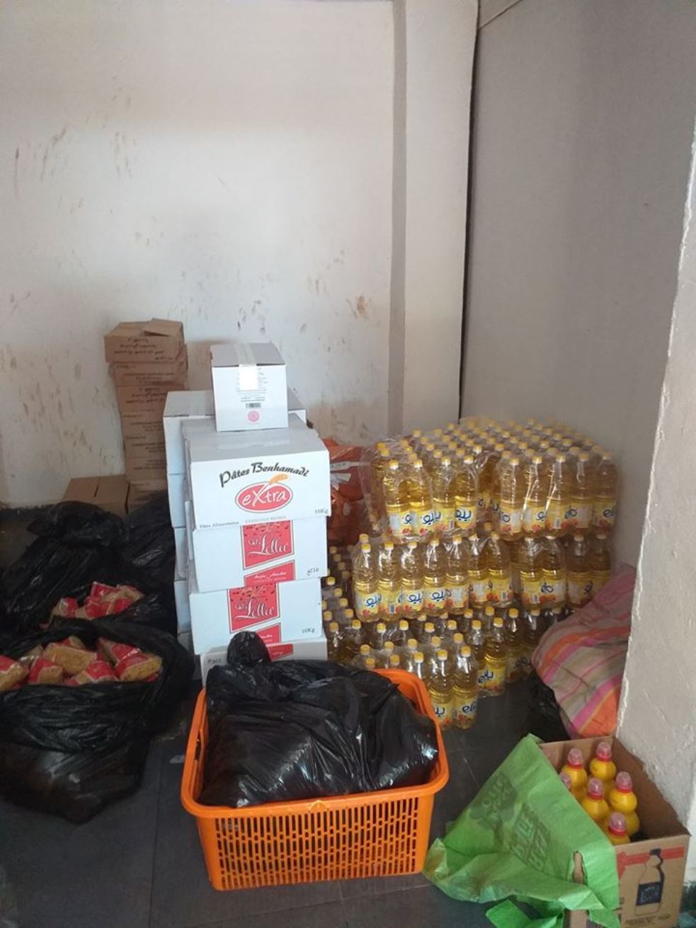 Image of a corner of a room, filled with bottles and food. 