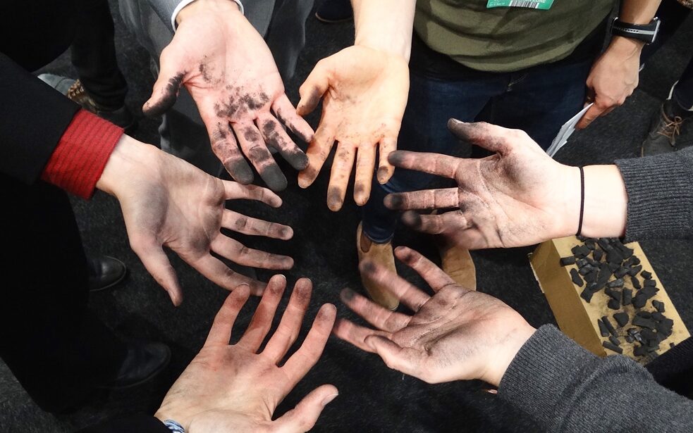 Foto von 6 russ-verschmierten Händen im Kreis