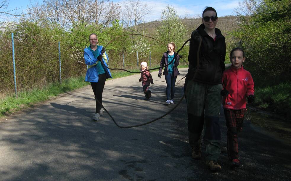 Frau trägt zusammen mit vier Mädchen Müll.