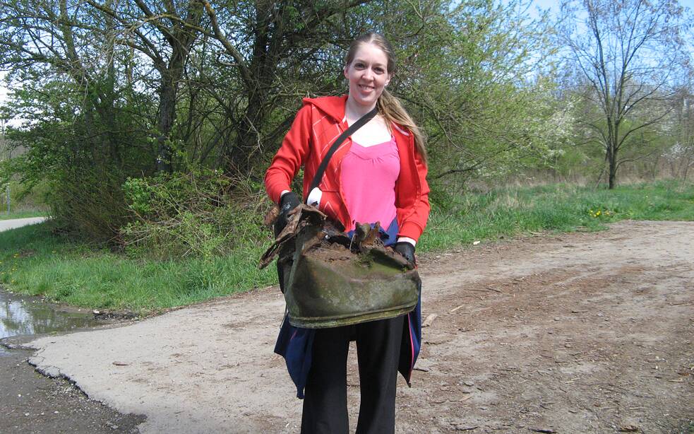 Junge Frau trägt alte verrostete Tonne.