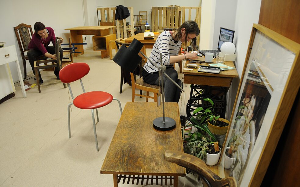 Zwei Frauen arbeiten an alten Möbeln.