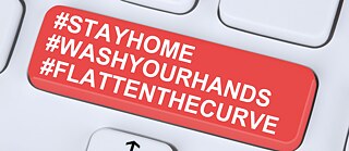 Toetsenbord met opschrift Stay at home, wash your hands, flatten the curve 