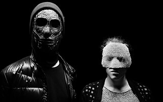 Zwei Personen mit Masken.