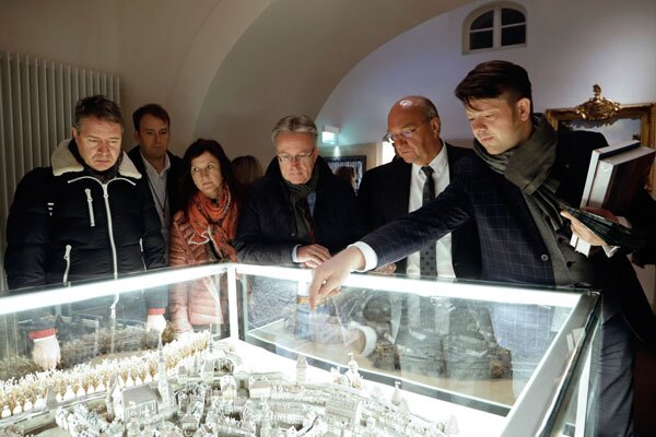 Zittaus OB Thomas Zenker zeigt einer EU-Delegation ein Miniaturmodell seiner Stadt. 